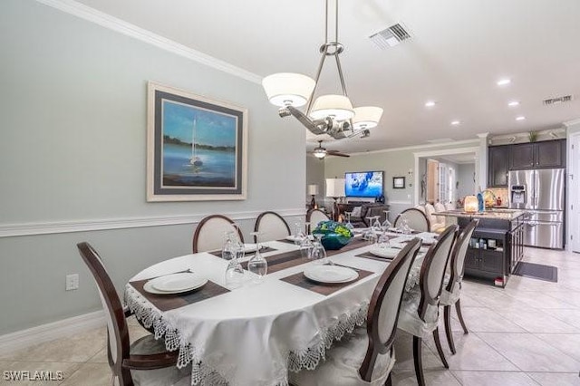 dining space with ceiling fan with notable chandelier, sink, light tile patterned floors, and crown molding