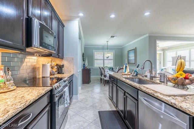 kitchen featuring light stone countertops, sink, stainless steel appliances, crown molding, and decorative light fixtures