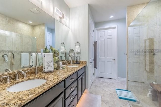 bathroom featuring tile patterned flooring, vanity, and a shower with shower door