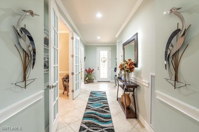 doorway featuring french doors, light tile patterned floors, and ornamental molding