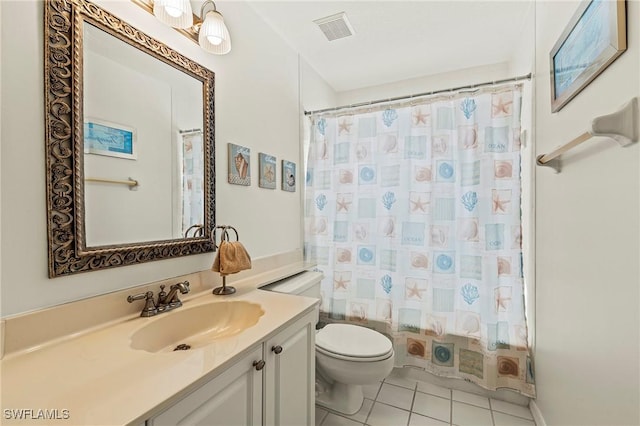 bathroom featuring tile patterned flooring, vanity, and toilet