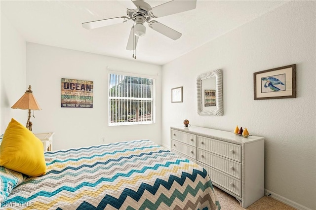 bedroom with ceiling fan and light carpet