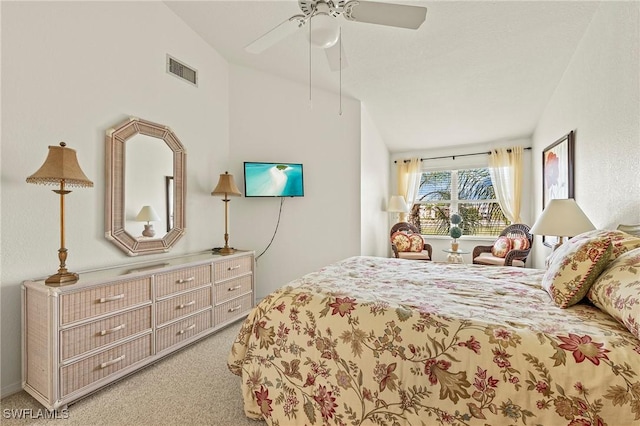 bedroom with ceiling fan, light colored carpet, and vaulted ceiling