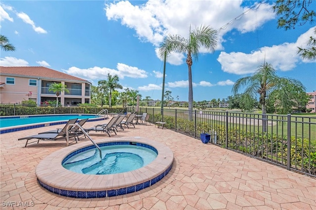 view of swimming pool featuring a community hot tub and a patio