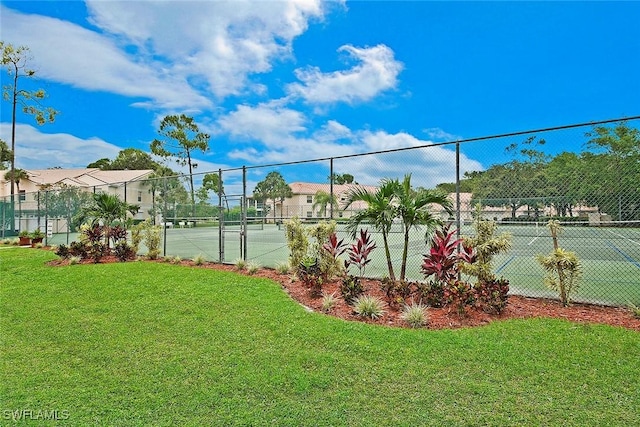 view of tennis court with a yard