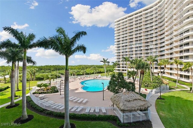 view of pool featuring a lawn and a patio