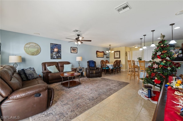 tiled living room featuring ceiling fan with notable chandelier