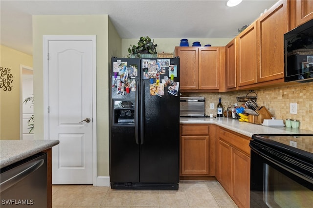 kitchen featuring light tile patterned floors, backsplash, and black appliances