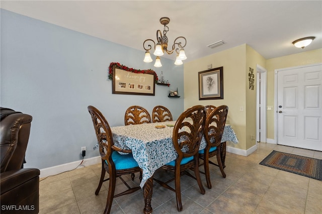 dining area featuring tile patterned flooring and a chandelier