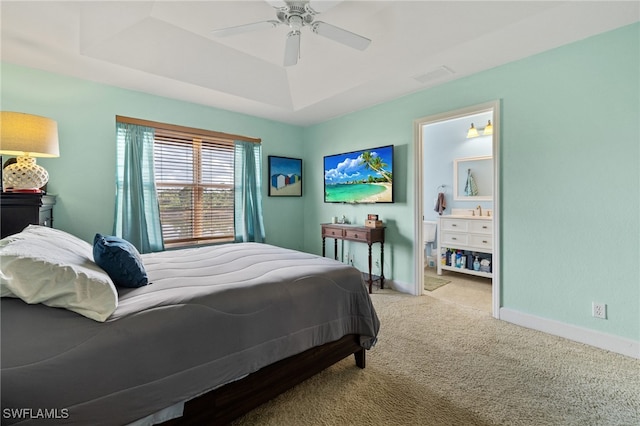 bedroom featuring a tray ceiling, ceiling fan, sink, and light carpet