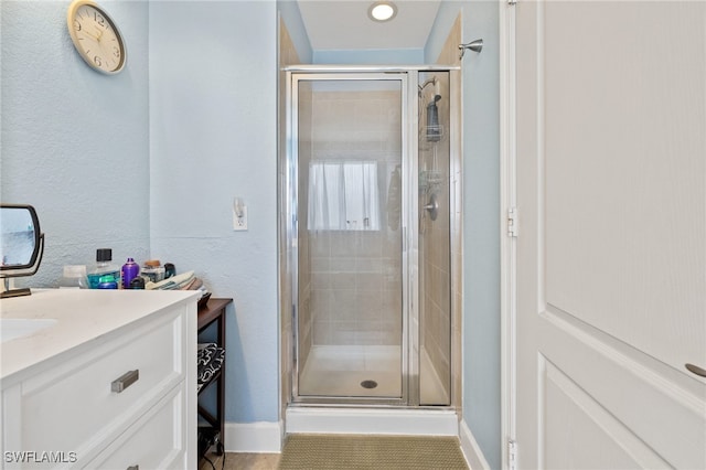 bathroom featuring tile patterned flooring, vanity, and a shower with door