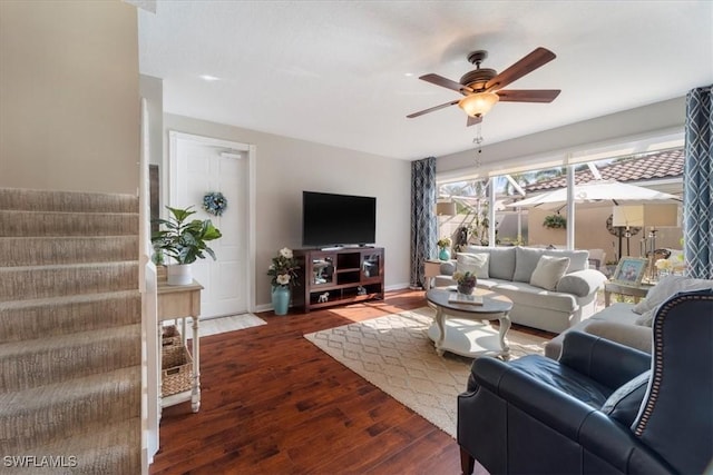 living room with ceiling fan and dark wood-type flooring