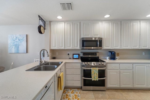 kitchen with white cabinets, light tile patterned floors, sink, and appliances with stainless steel finishes