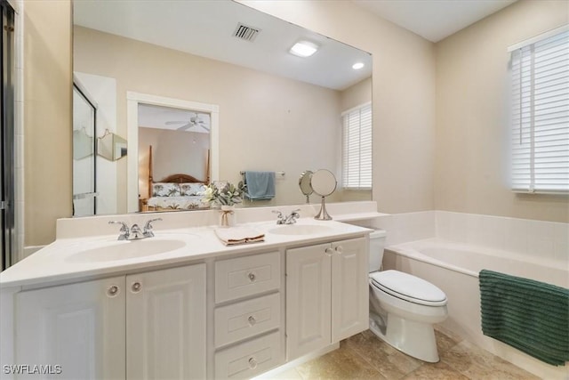 bathroom with vanity, tile patterned flooring, ceiling fan, a washtub, and toilet