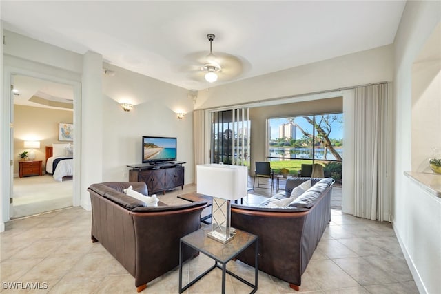 living area featuring light tile patterned floors, baseboards, and a ceiling fan