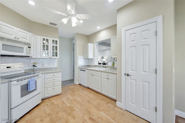 kitchen featuring white appliances, white cabinetry, decorative backsplash, sink, and light wood-type flooring