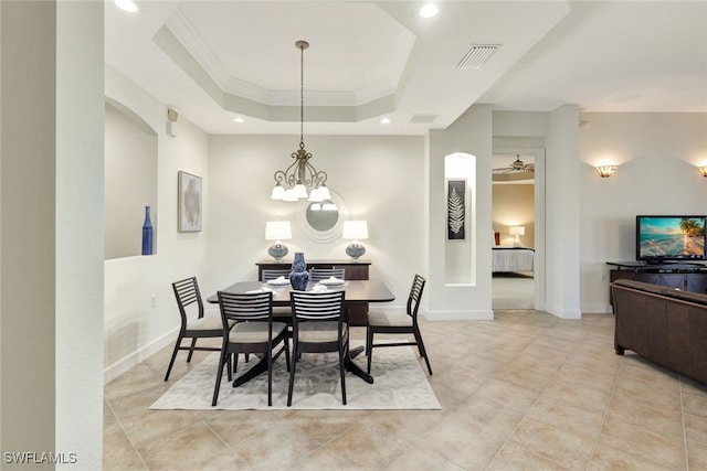 dining space with light tile patterned floors, ornamental molding, and a raised ceiling