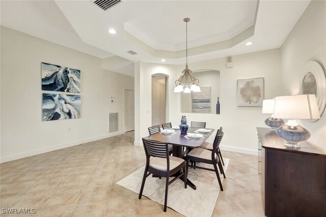 dining room featuring crown molding, a raised ceiling, and an inviting chandelier