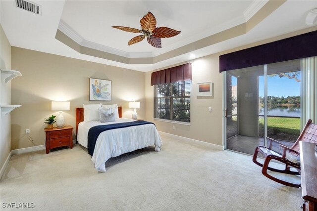 carpeted bedroom featuring ceiling fan, a water view, a raised ceiling, and access to outside