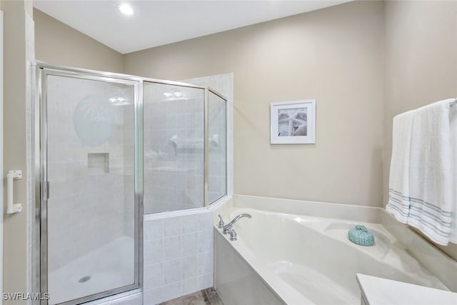 bathroom with a shower stall and a garden tub