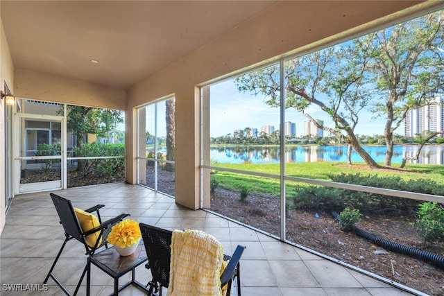 sunroom with a city view and a water view