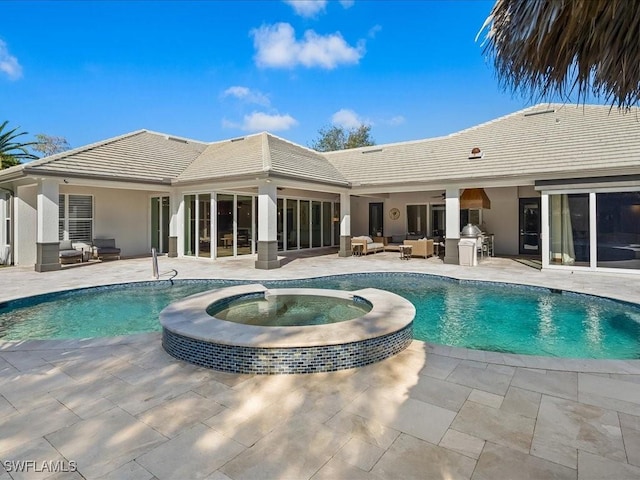 view of swimming pool with exterior kitchen, a patio area, an outdoor hangout area, and an in ground hot tub