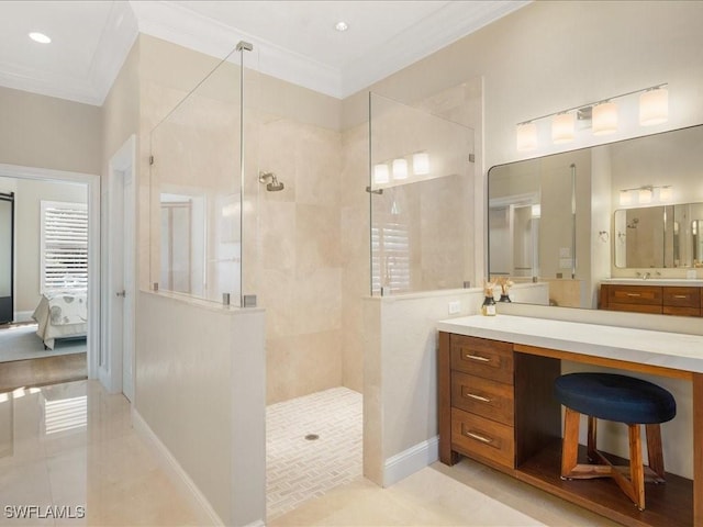 bathroom with tiled shower, vanity, crown molding, and tile patterned flooring