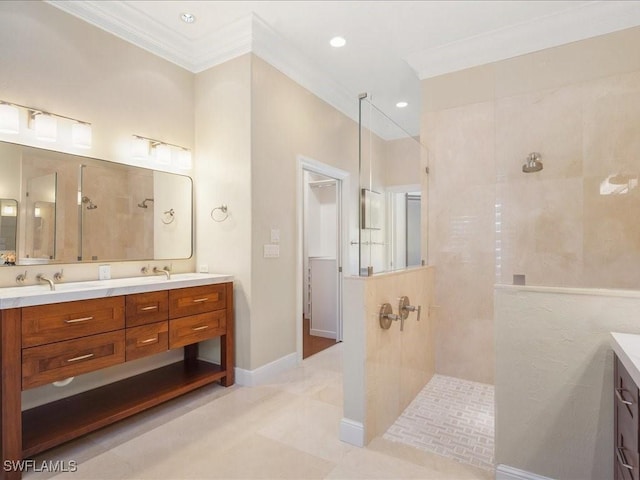 bathroom with a tile shower, vanity, and ornamental molding