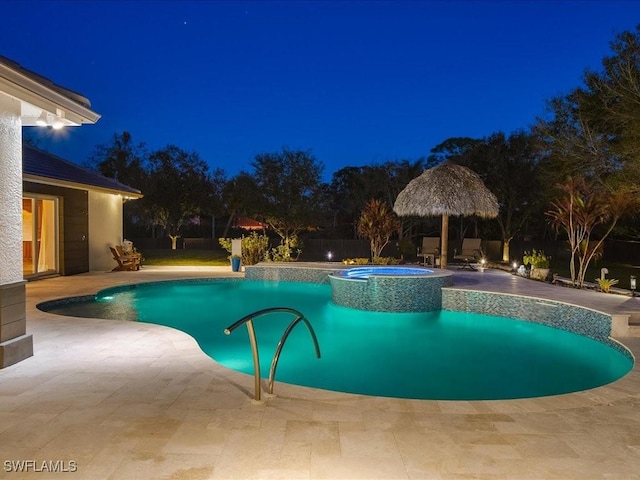 pool at night featuring an in ground hot tub, a gazebo, and a patio area