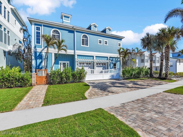 view of front of home featuring a garage, decorative driveway, and a front lawn