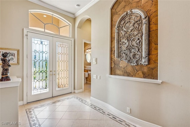 foyer with ornamental molding, light tile patterned floors, and french doors