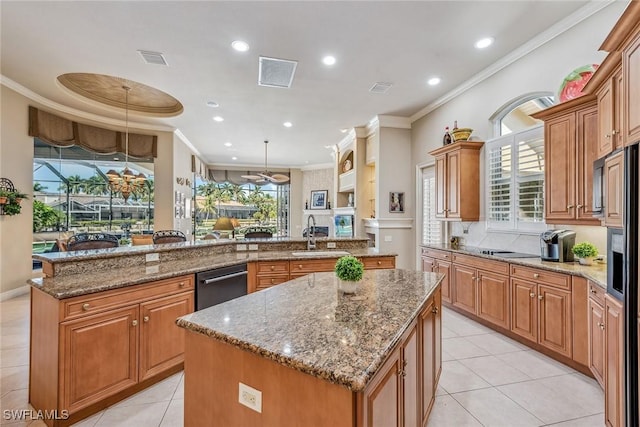 kitchen featuring light stone countertops, ornamental molding, sink, a kitchen island, and hanging light fixtures