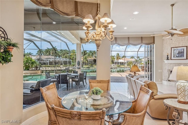 dining room with light tile patterned floors and ceiling fan with notable chandelier