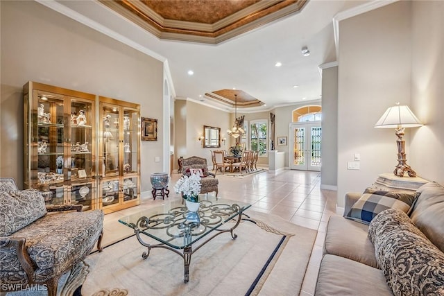 tiled living room with a notable chandelier, french doors, crown molding, and a tray ceiling