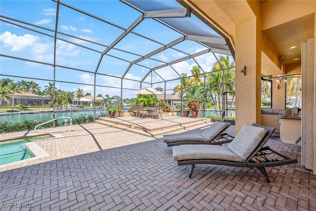 view of patio with glass enclosure and a water view