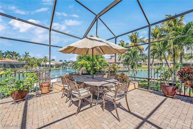 view of patio / terrace featuring a lanai and a water view