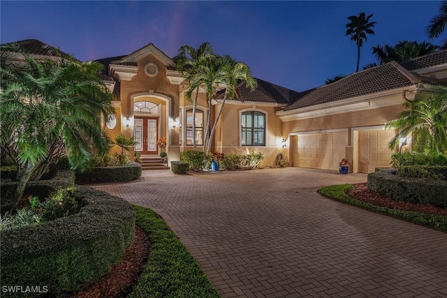 mediterranean / spanish-style house with a garage and french doors