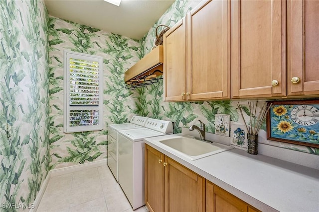 washroom with cabinets, washing machine and dryer, light tile patterned flooring, and sink