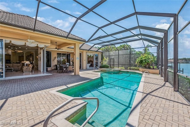 view of swimming pool with a lanai, a pool with connected hot tub, ceiling fan, and a patio