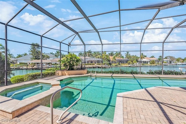 view of swimming pool with a water view, glass enclosure, a pool with connected hot tub, and a patio