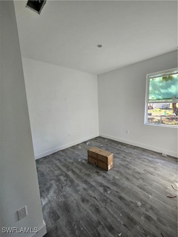 unfurnished room with dark wood-type flooring