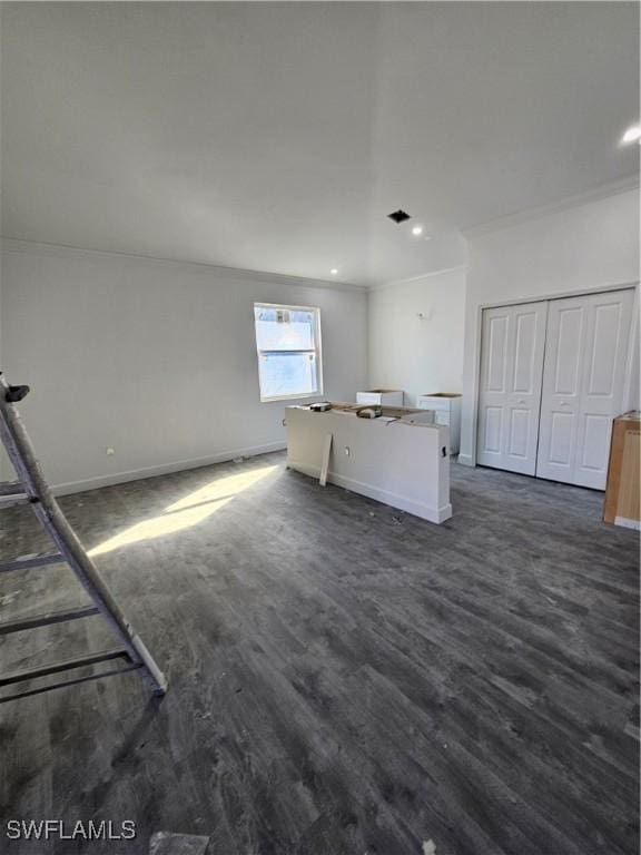 unfurnished living room featuring dark wood-type flooring and ornamental molding