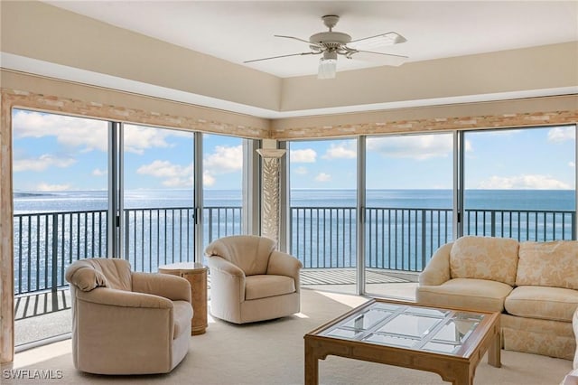 sunroom with a water view and ceiling fan