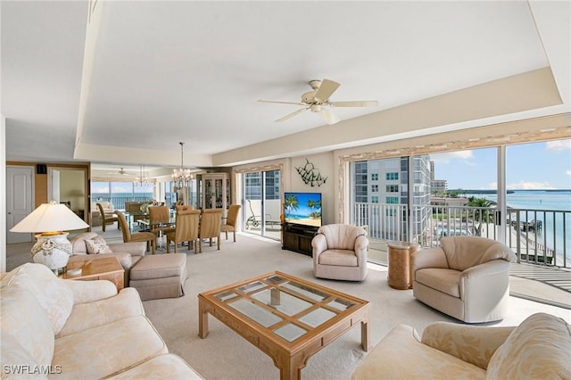 living room featuring light carpet and ceiling fan with notable chandelier