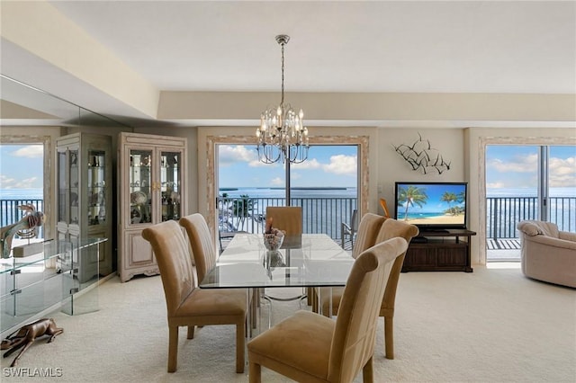 dining room featuring light colored carpet and an inviting chandelier