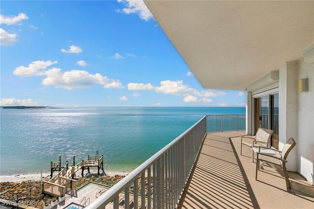 balcony featuring a beach view and a water view