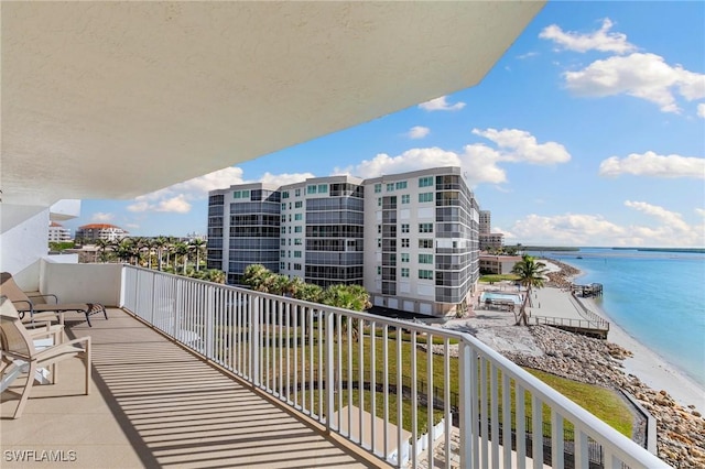 balcony with a water view and a view of the beach