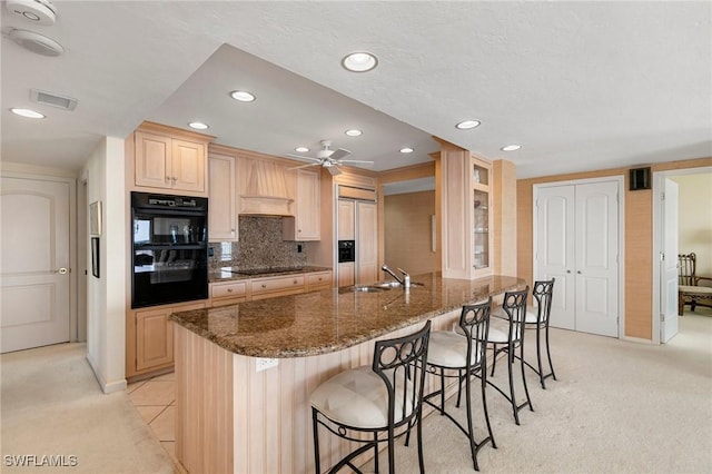 kitchen featuring light brown cabinetry, ceiling fan, black appliances, and sink