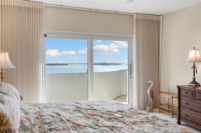 carpeted bedroom with access to outside and a water view