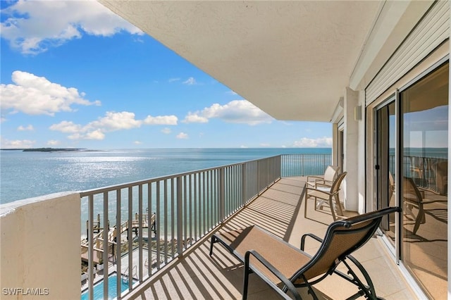 balcony with a water view and a view of the beach